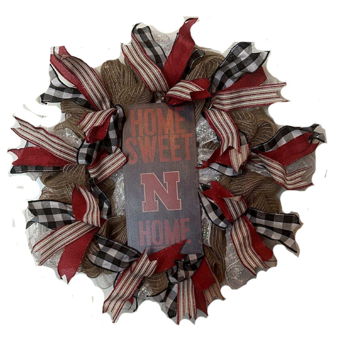 Decorative wreath with 'Home Sweet Home' and 'Nebraska' logo with red and white accents